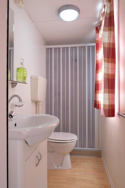 Bagno con lavabo e doccia a tenda.