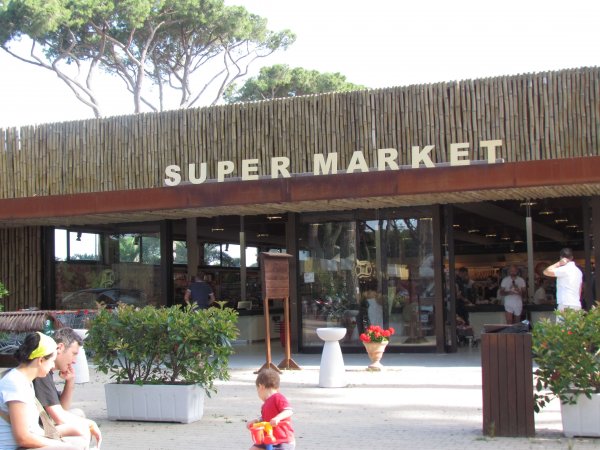 Entrata di un supermercato con persone sedute.