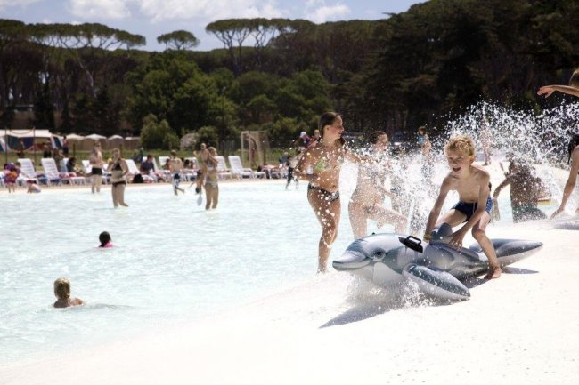 Bambini giocano in piscina con gonfiabile.