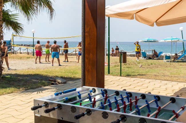 Calciobalilla e partita di beach volley sullo sfondo.