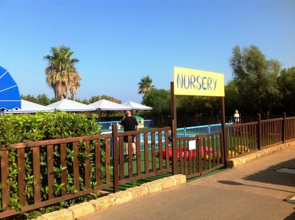 Un recinto con un'area verde e l'insegna gialla 