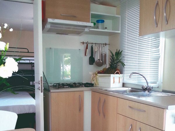 Cucina moderna con fornelli e lavandino, mobili chiari.