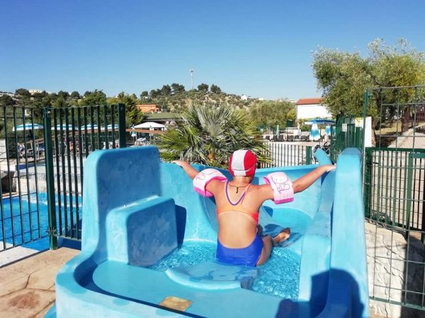 Persona in costume da bagno su uno scivolo acquatico.
