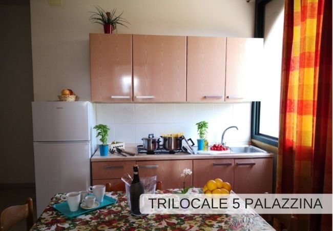Cucina con tavolo apparecchiato e frigorifero.