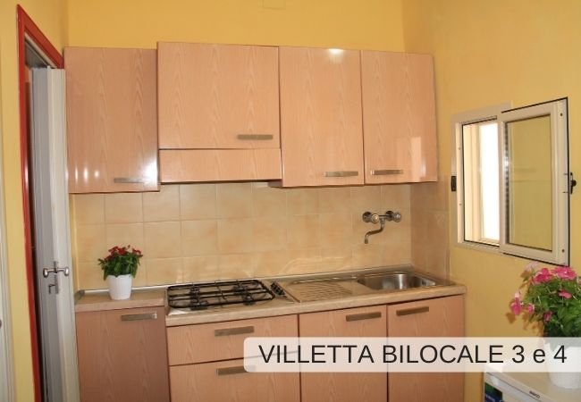 Cucina con mobili chiari e finestra.