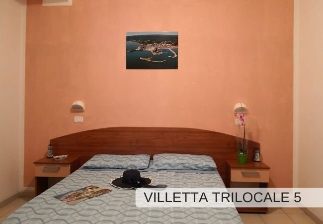 Camera con parete rosa e letto matrimoniale.