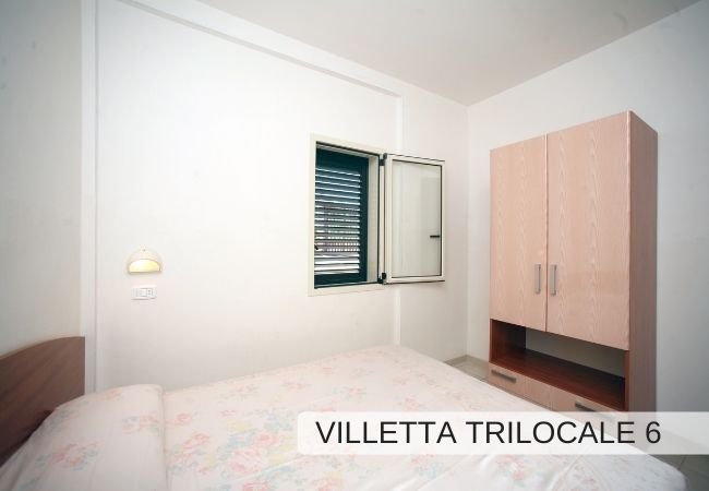 Stanza con letto, armadio e finestra.