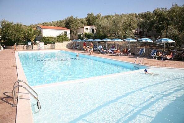 Piscina con lettini e ombrelloni.