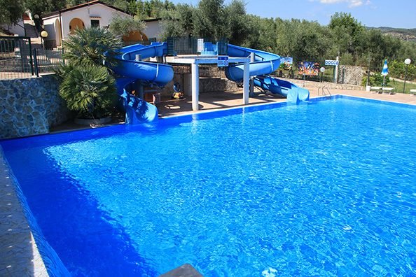 Piscina blu con scivolo a serpentina.