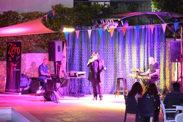 Concerto dal vivo su un palco illuminato con musicisti.
