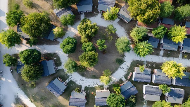 Veduta aerea di bungalow tra alberi.