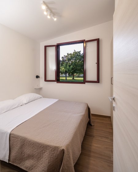 Camera con letto matrimoniale e finestra aperta.