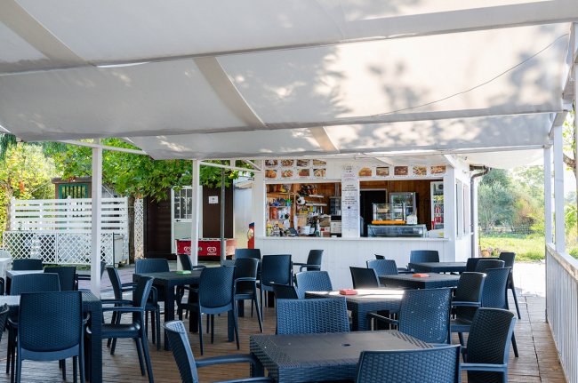 Area all'aperto con sedie e tavoli neri.