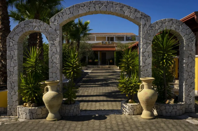 Un ingresso con archi in pietra e vasi decorativi.