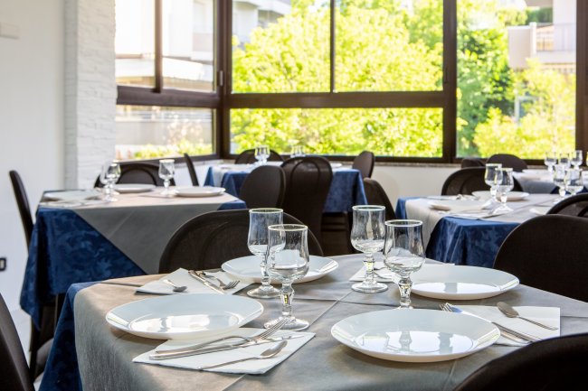 Tavoli apparecchiati in un ristorante luminoso.