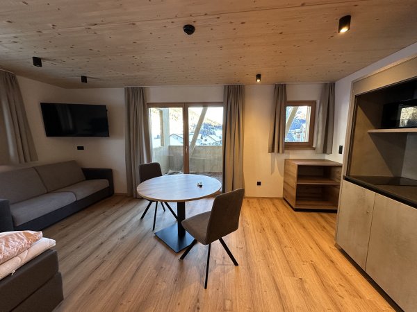 Sala con tavolo rotondo, divano e TV.