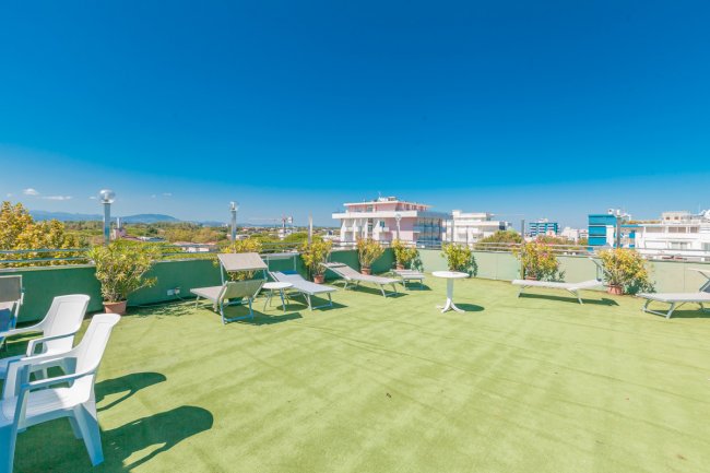 Terrazza con lettini e vista su edifici.