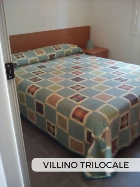 Camera con letto matrimoniale e copriletto multicolore.