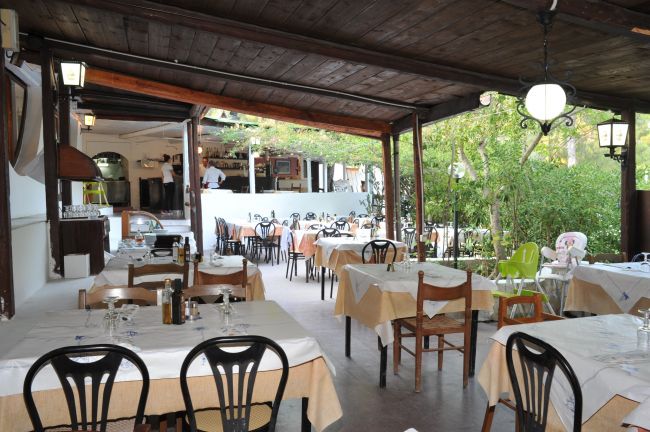 Ristorante all'aperto con tavoli apparecchiati.
