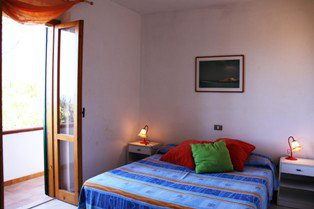 Camera con letto matrimoniale e accesso al balcone.