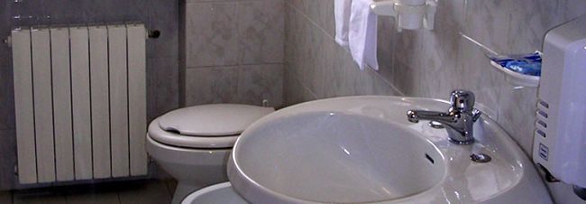 Un lavandino vicino a un WC e un radiatore.