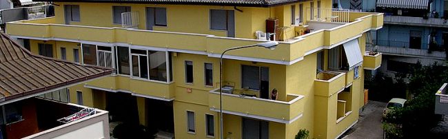 Un edificio residenziale giallo su più piani.