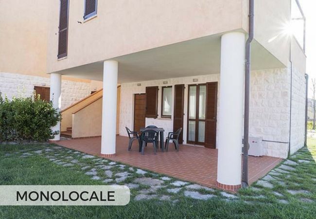 Portico con tavolo e sedie di plastica, cartello 