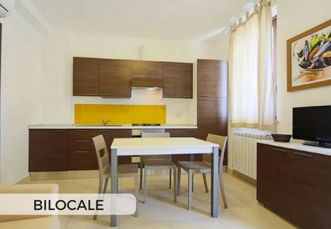 Bilocale con cucina moderna e tavolo.