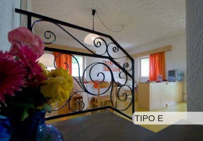 Interno con fiori, tavolo e finestre arancioni.