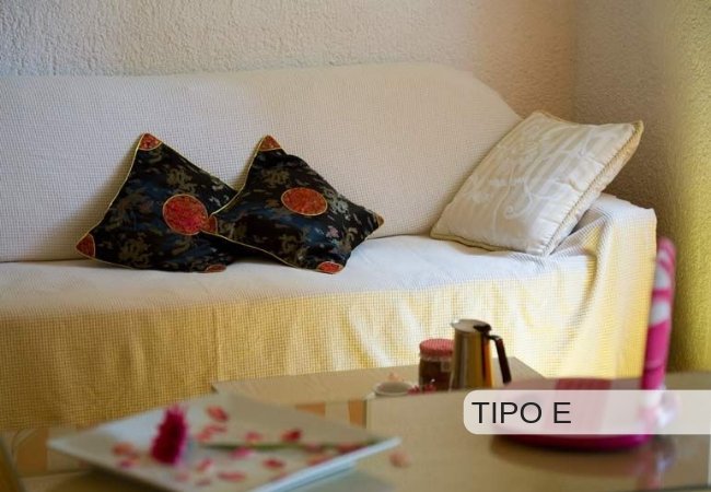 Divano bianco con cuscini decorativi.