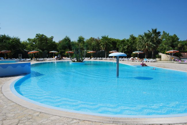 Grande piscina all'aperto con ombrelloni.