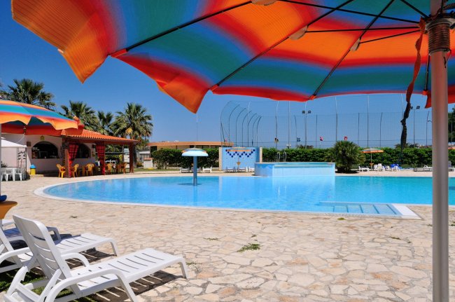 Piscina circondata da ombrelloni colorati.