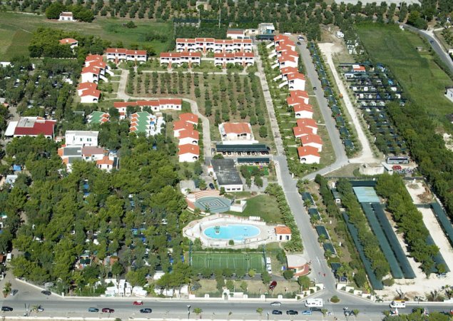 Vista aerea di un complesso con edifici e piscina.