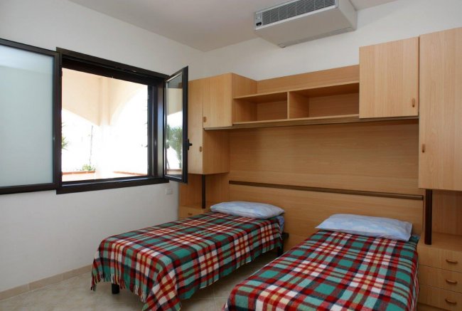 Camera da letto con due letti singoli e plaid a quadri.