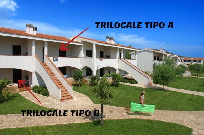 Complesso residenziale con scale esterne e prato.