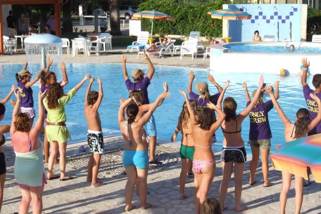 Gruppo di persone che fa attività in una piscina all'aperto.