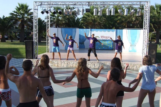 Persone ballano di fronte a un palco all'aperto.