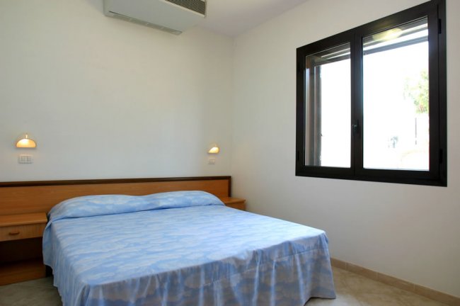 Camera da letto con letto matrimoniale e finestra.