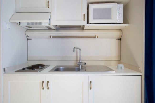 Cucina compatta con microonde e piano cottura.