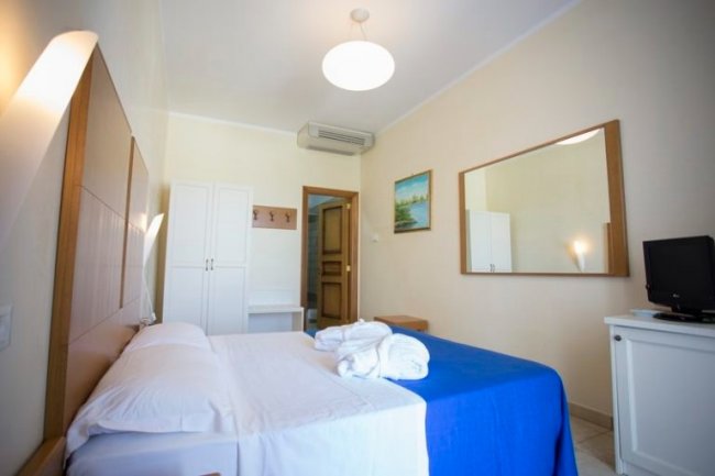 Interno di una camera d'albergo con letto matrimoniale.