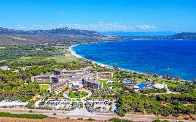 Resort vicino al mare con ampi edifici e alberi.