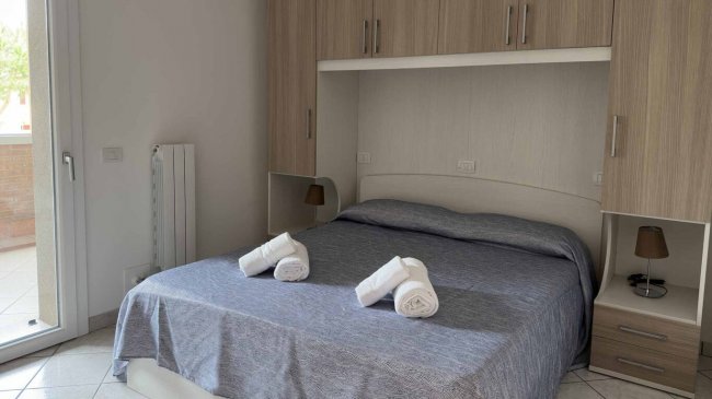 Camera da letto con letto matrimoniale e asciugamani.