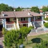 Una casa a due piani con balconi e giardino.