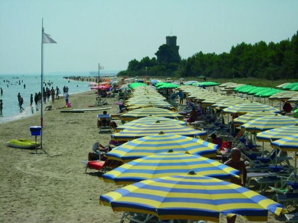 Spiaggia con ombrelloni a righe gialle e blu.