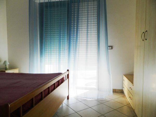 Camera con letto matrimoniale e tenda azzurra.