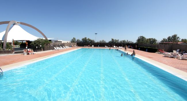 Ampia piscina all'aperto con bagnanti.