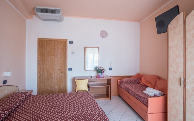 Camera d'albergo con letto matrimoniale e divano letto.