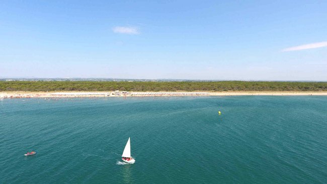 Vista mare con una barca a vela.