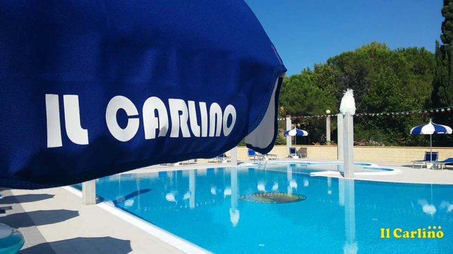 Piscina all'aperto con ombrellone blu e 