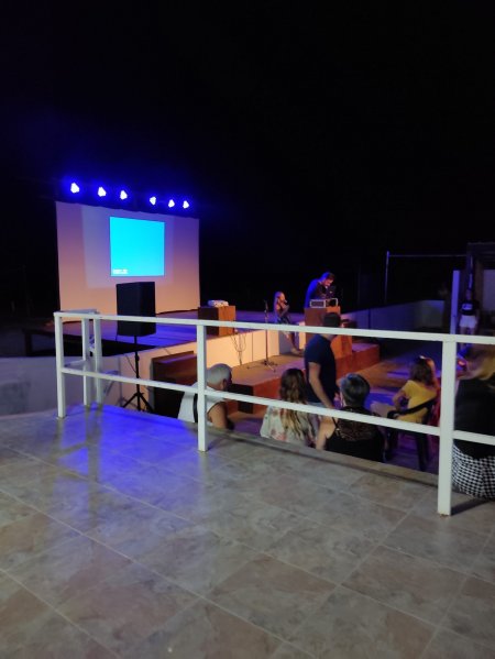 Palco illuminato con persone in attesa.
